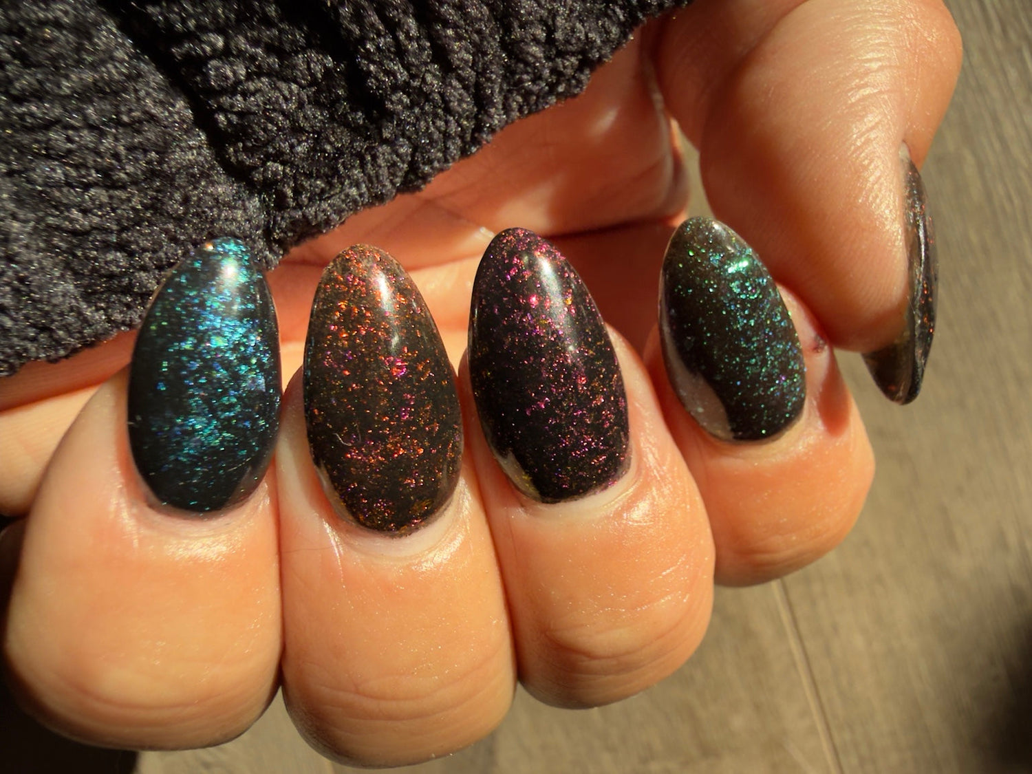 Black chameleon flake manicure featuring Zero Regrets, natural-light view 1