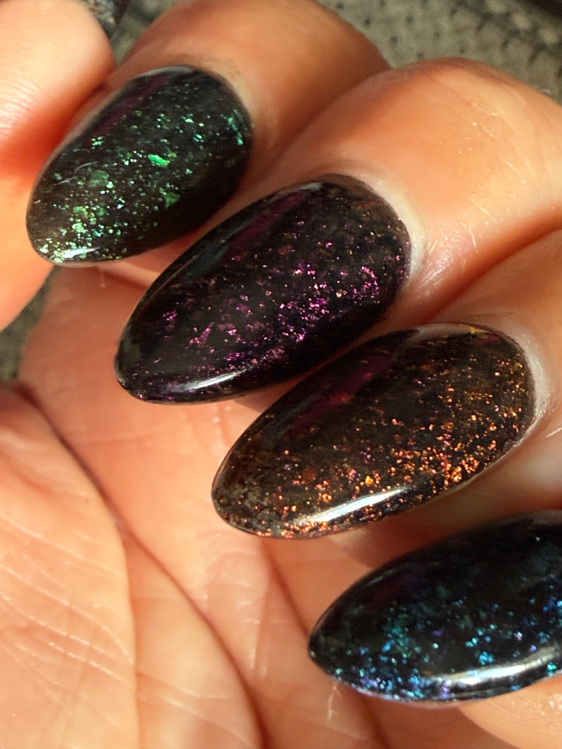 Black chameleon flake manicure featuring Envy Me in natural light
