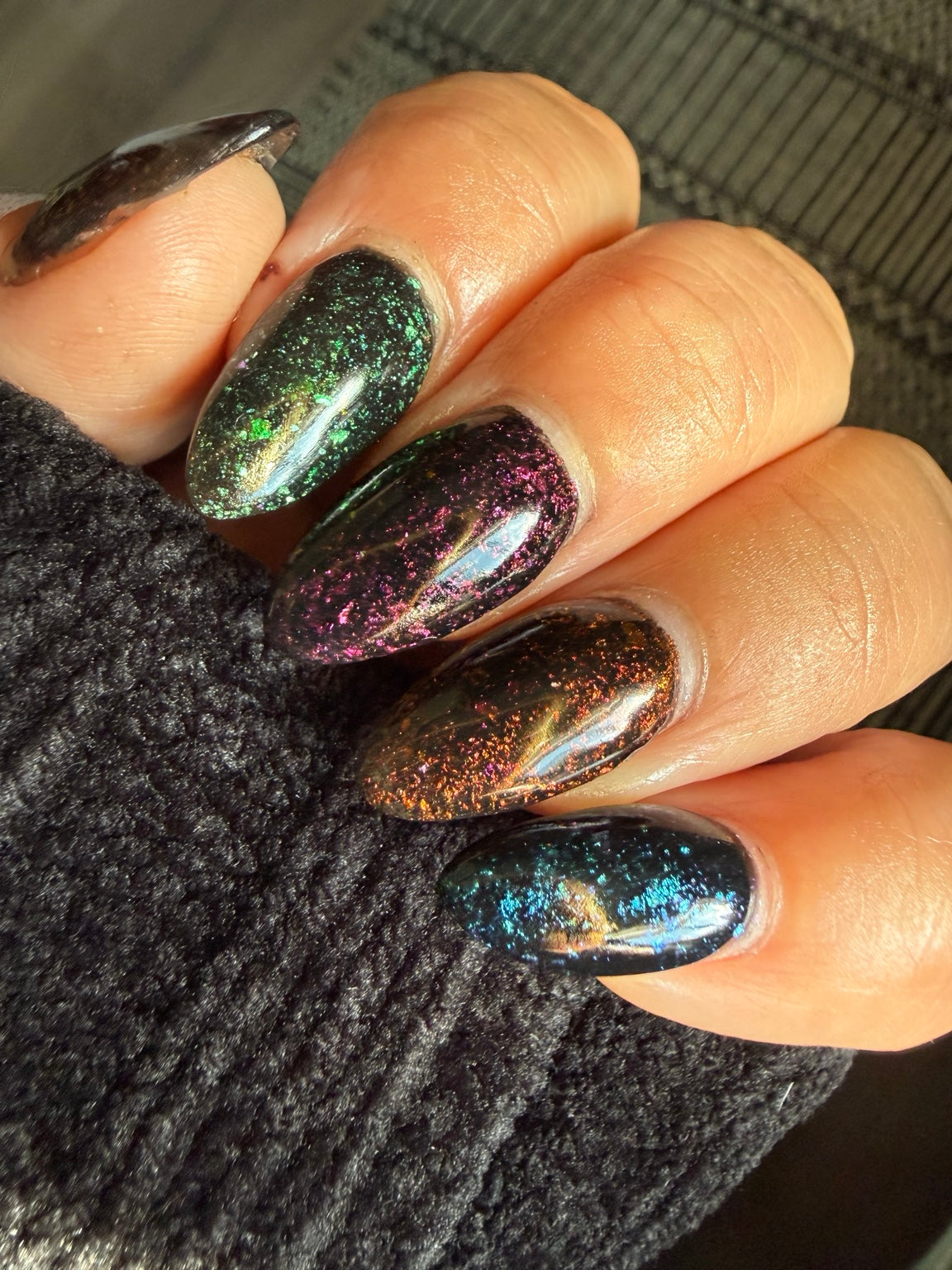 Black chameleon flake manicure featuring Zero Regrets in sunlight