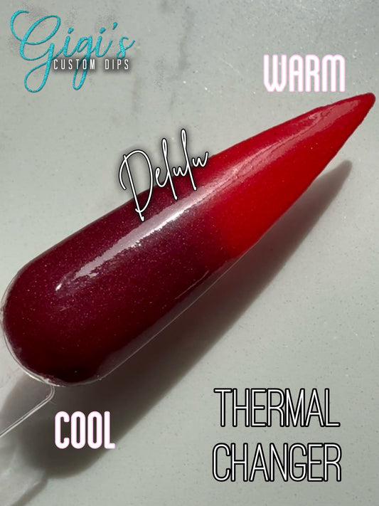 Labeled Delulu thermal dip powder swatch showing cool deep burgundy and warm bright red