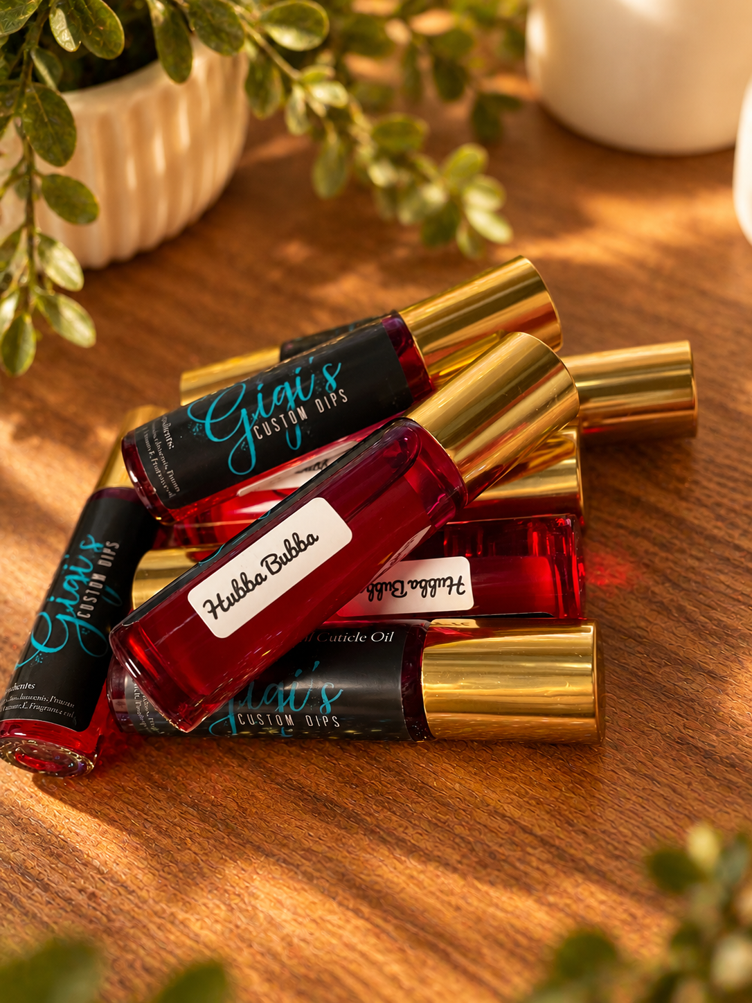 Styled product photo of Hubba Bubba Cuticle Roller cuticle oil with warm wood, greenery, and cream accents