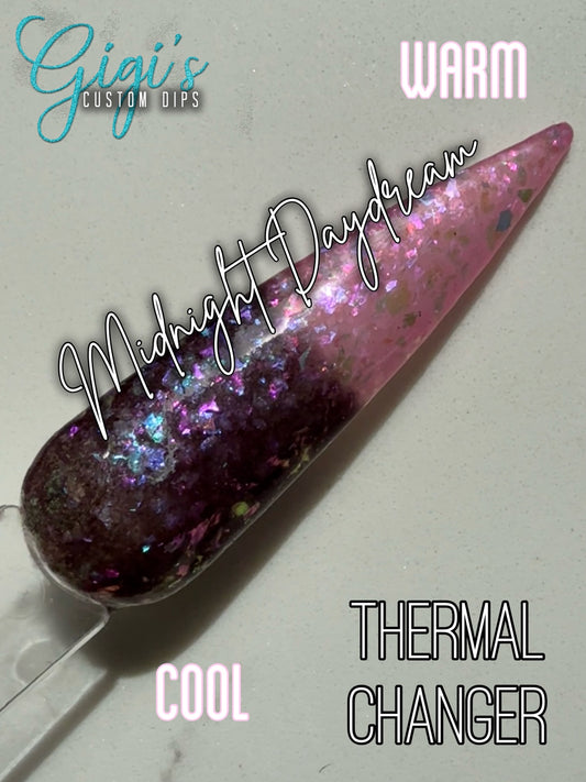 Labeled Midnight Daydream thermal dip powder shifting from cool deep plum to warm blush pink with iridescent flakes
