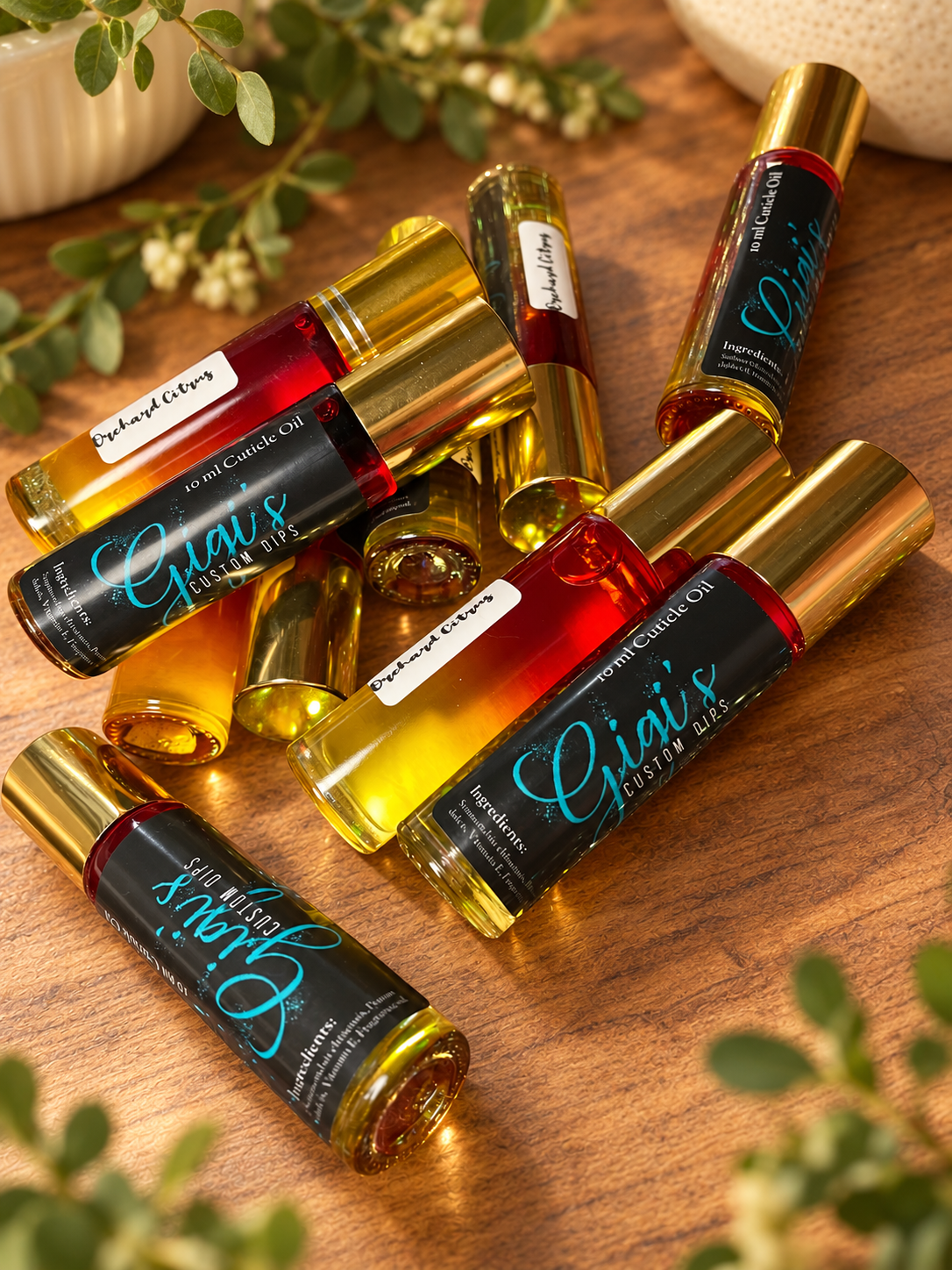 Styled product photo of Orchard Citrus Cuticle Roller cuticle oil with warm wood, greenery, and cream accents