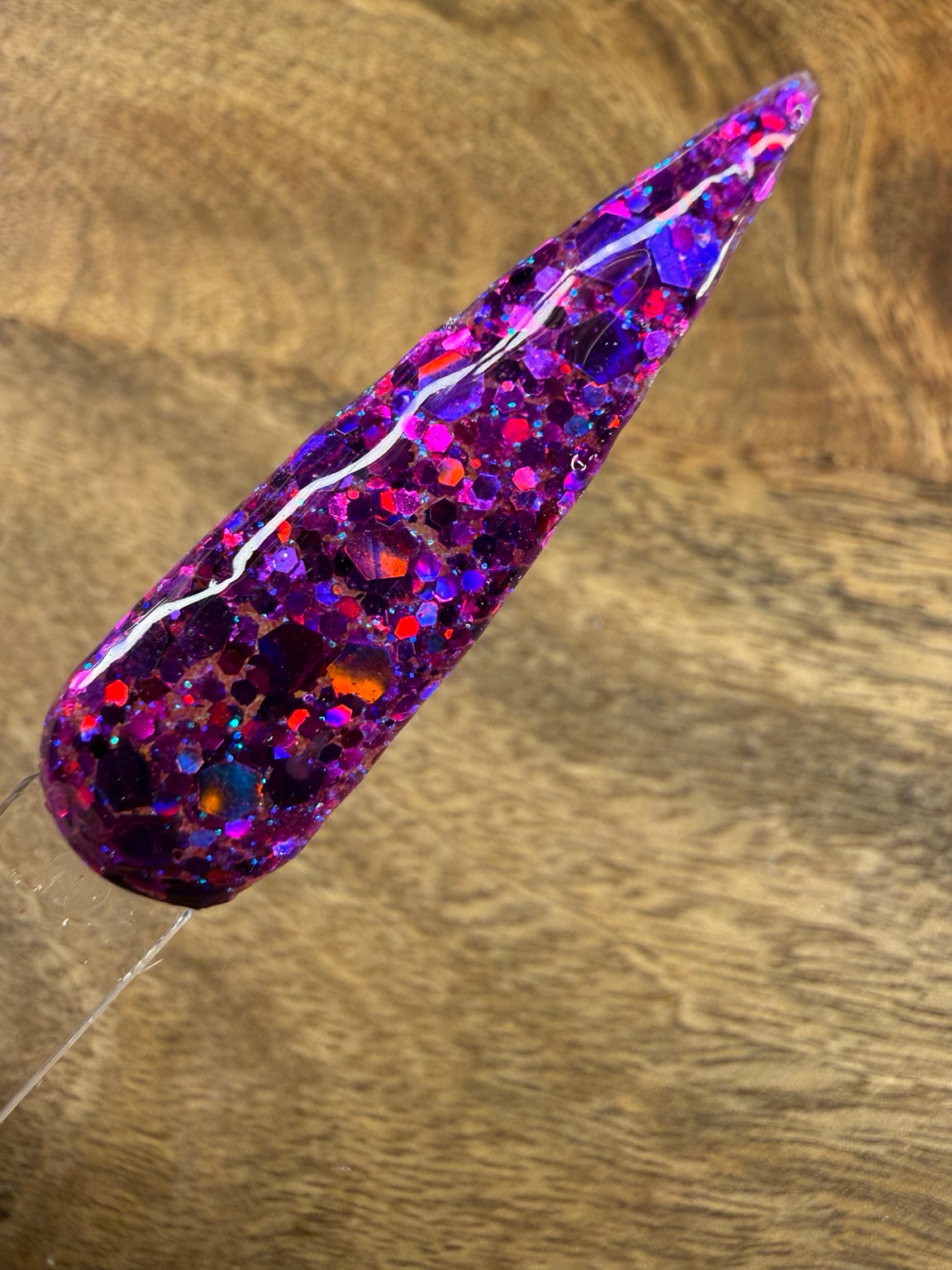 Spell Check chunky purple glitter dip powder swatch on wood background