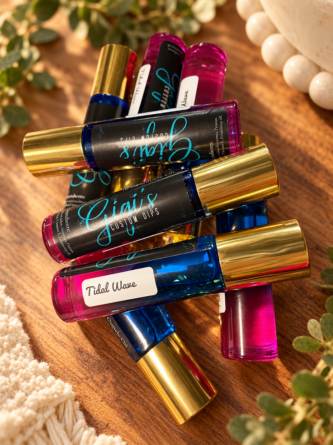 Styled product photo of Tidal Wave Cuticle Roller cuticle oil with warm wood, greenery, and cream accents