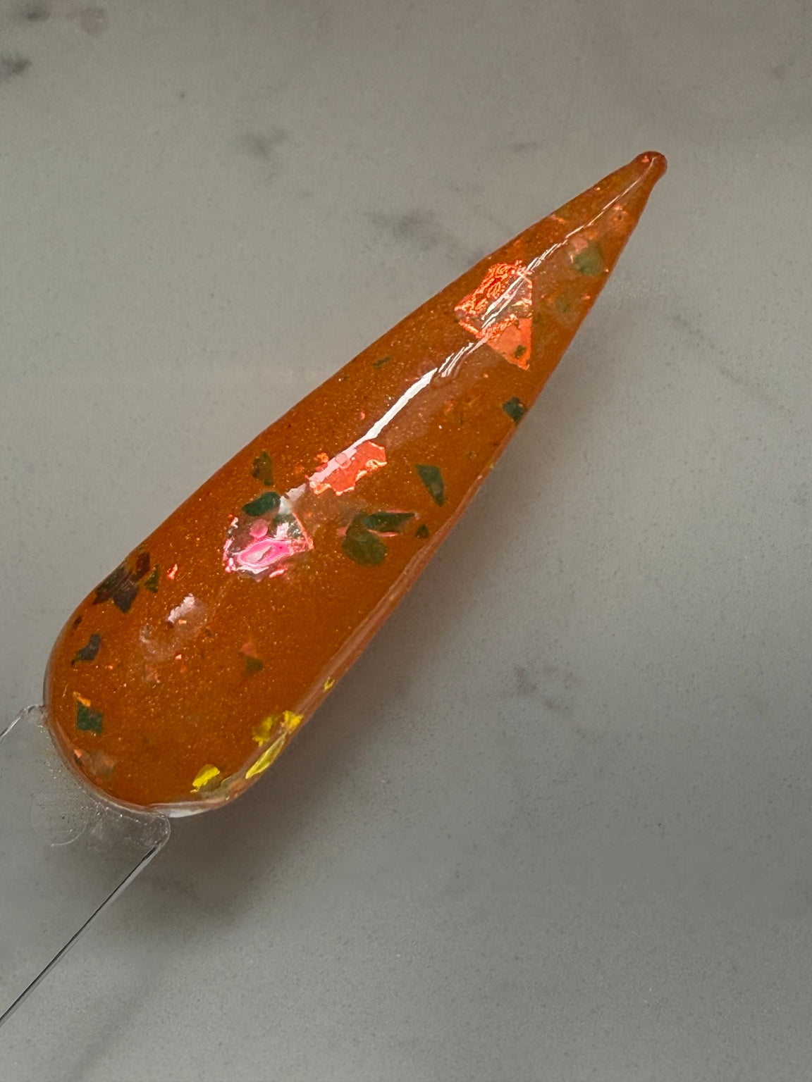 Unfortunately Obsessed orange dip powder with green, gold, bronze and pink colour-shifting flakes