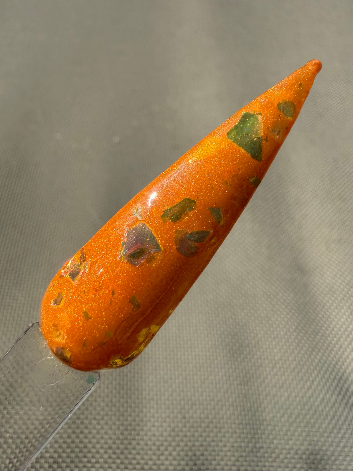 Unfortunately Obsessed orange dip powder with green, gold, bronze and pink colour-shifting flakes